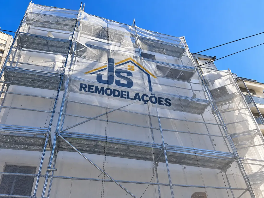 Fachada com tela de proteção identificada com JS Remodelações.