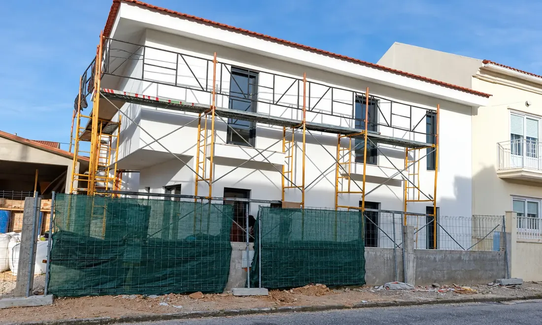 Moradia em obra com andaimes instalados na fachada.