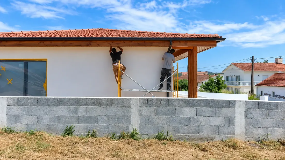 Trabalhos exteriores em moradia com equipa em andaime.